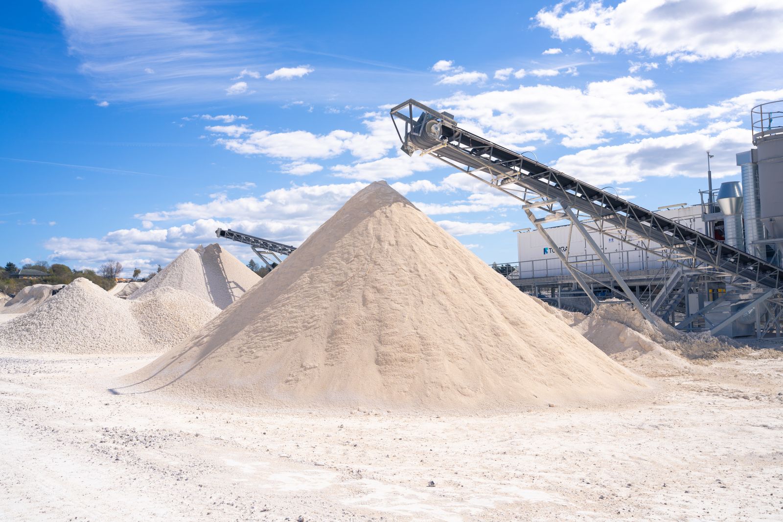 Sand and gravel stockpiles under a conveyor at a quarry